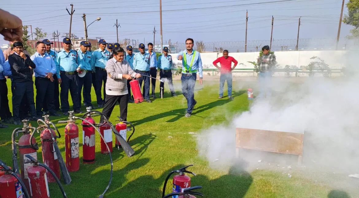 Fire safety training session with practical extinguisher demonstration in an industrial facility
